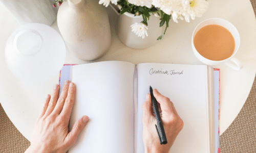 Woman writing in gratitude journal